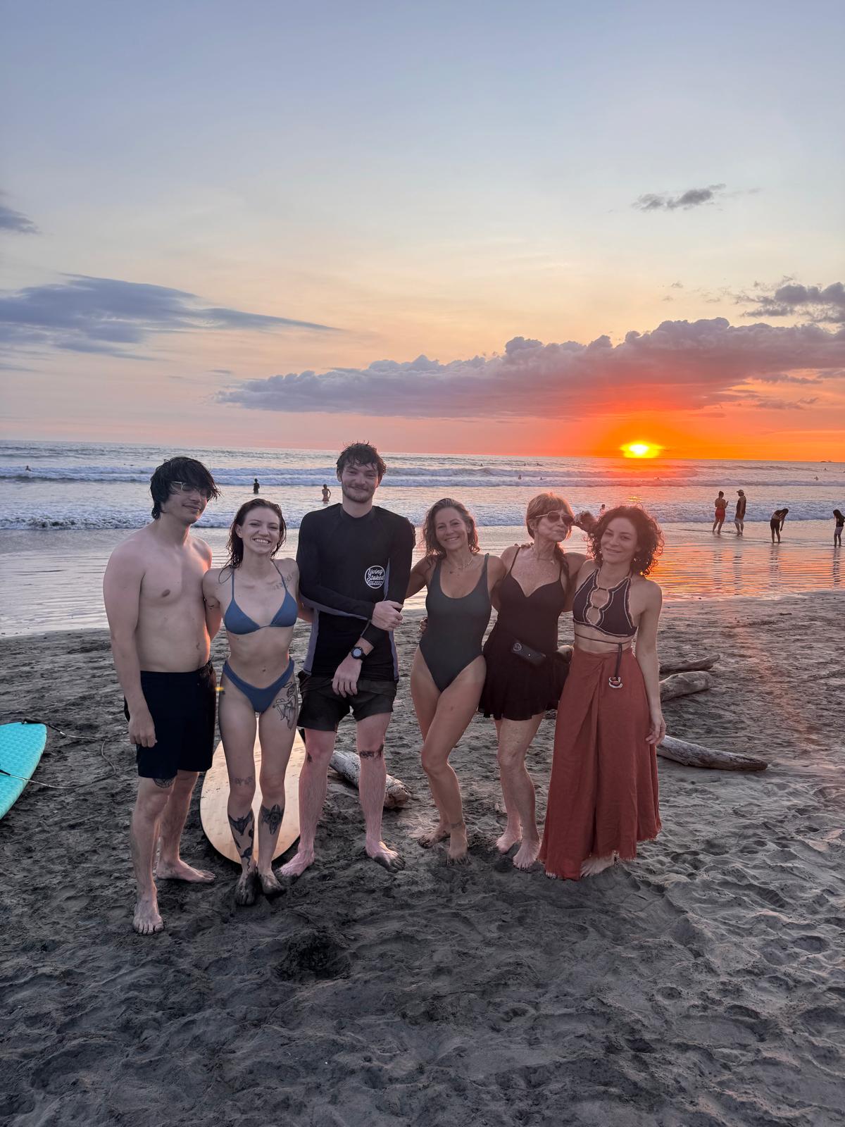 Group of young adults together on the beach at sunset